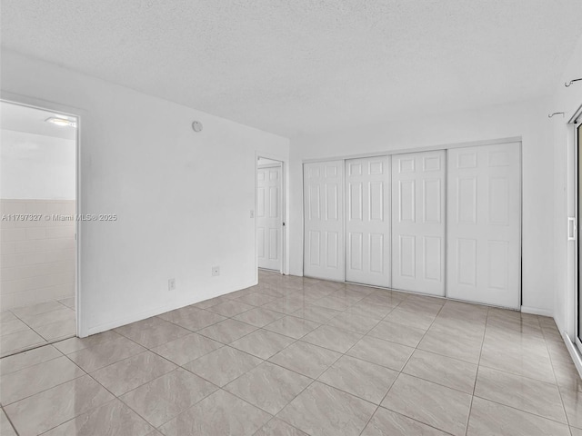 374 Tilford R Unit 374, Deerfield Beach, FL 33442 - unfurnished bedroom featuring a textured ceiling, a closet, and light tile patterned floors