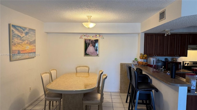 dining area with light tile patterned floors and a textured ceiling