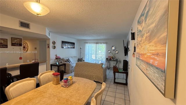 dining room with light tile patterned flooring and a textured ceiling