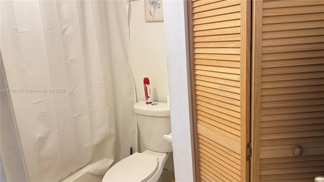 bathroom with toilet and curtained shower