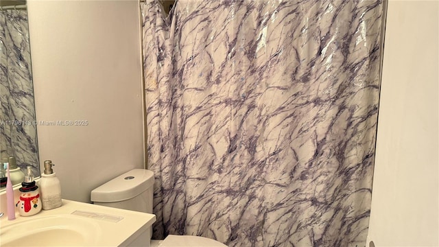 full bathroom featuring toilet, vanity, and a shower with curtain