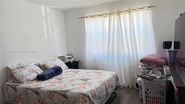 bedroom with wood finished floors and a textured ceiling