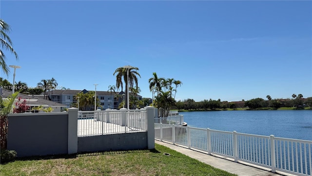 fenced yard featuring a water view