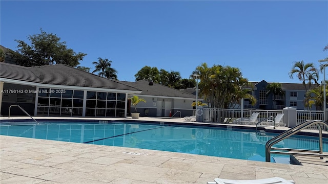 community pool featuring fence and a patio area