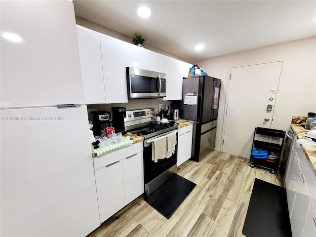 800 NE 195th St Unit 720, Miami, FL 33179 - kitchen featuring stainless steel appliances, light wood-style floors, white cabinetry, light countertops, and recessed lighting