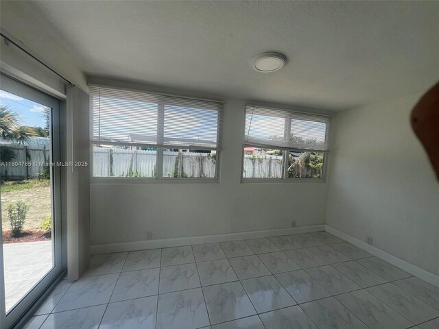 18740 NW 42nd Pl, Miami Gardens, FL 33055 - spare room with light marble finish flooring, baseboards, and a water view