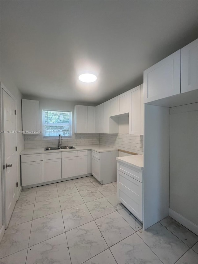18740 NW 42nd Pl, Miami Gardens, FL 33055 - kitchen with a sink, light marble finish floors, backsplash, and white cabinets