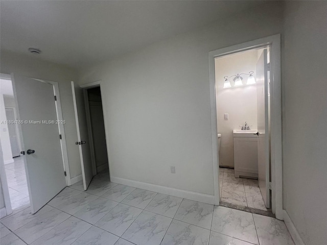18740 NW 42nd Pl, Miami Gardens, FL 33055 - unfurnished bedroom featuring light marble finish floors, baseboards, a sink, and ensuite bath