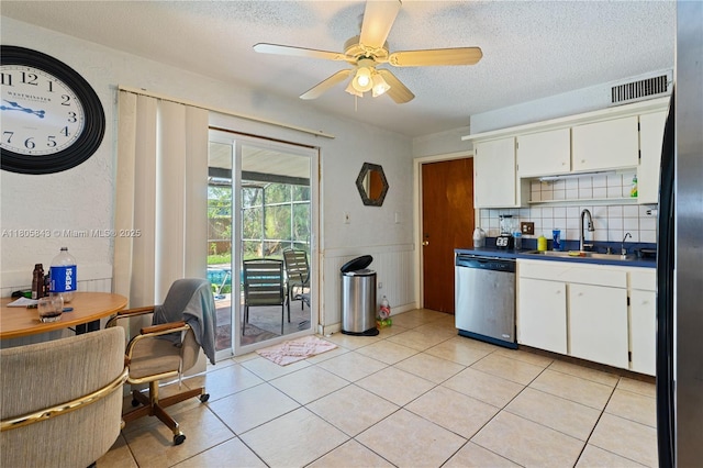 280 Palm Blvd, Merritt Island, FL 32952 - kitchen with stainless steel dishwasher, a sink, a textured ceiling, dark countertops, and white cabinetry