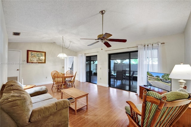 1561 NW 98th Ter, Pembroke Pines, FL 33024 - living area with light wood-style floors, a ceiling fan, vaulted ceiling, a textured ceiling, and baseboards