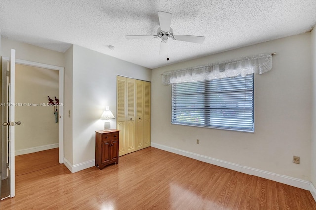 1561 NW 98th Ter, Pembroke Pines, FL 33024 - unfurnished bedroom with light wood-style floors, a closet, baseboards, a textured ceiling, and a ceiling fan