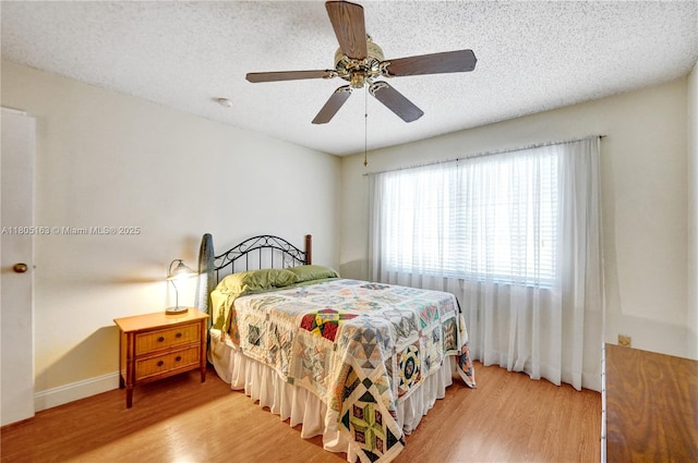 1561 NW 98th Ter, Pembroke Pines, FL 33024 - bedroom featuring wood finished floors, a textured ceiling, baseboards, and ceiling fan