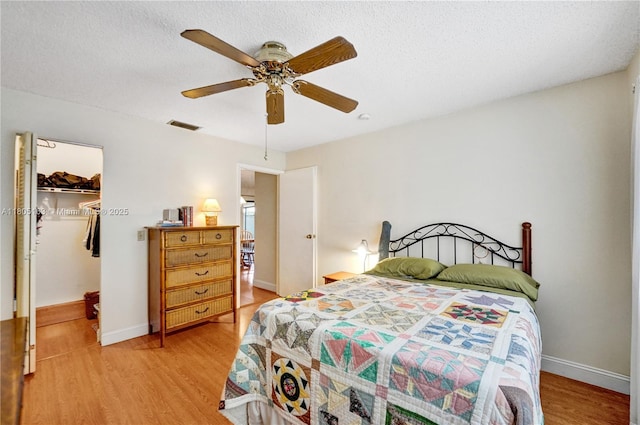 1561 NW 98th Ter, Pembroke Pines, FL 33024 - bedroom featuring light wood finished floors, a spacious closet, a closet, ceiling fan, and baseboards