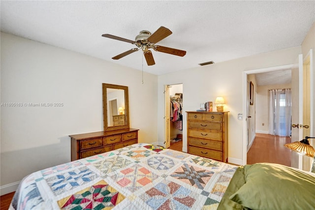 1561 NW 98th Ter, Pembroke Pines, FL 33024 - bedroom featuring wood finished floors, a spacious closet, a closet, a ceiling fan, and baseboards