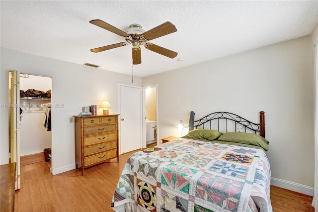 1561 NW 98th Ter, Pembroke Pines, FL 33024 - bedroom with a walk in closet, light wood-style floors, a closet, a ceiling fan, and baseboards