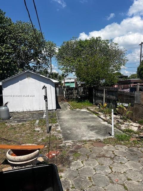707 N J St, Lake Worth, FL 33460 - view of yard featuring fence, a patio, an outbuilding, and a storage shed