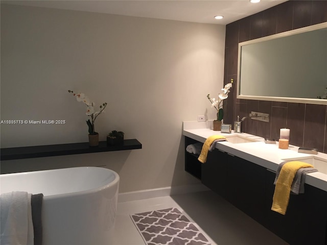 19707 Turnberry Way Unit 18D, Aventura, FL 33180 - bathroom with tasteful backsplash, recessed lighting, vanity, a freestanding tub, and baseboards