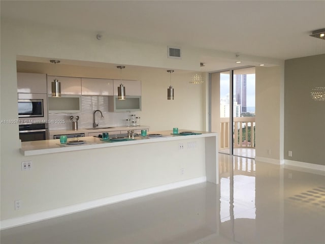 19707 Turnberry Way Unit 18D, Aventura, FL 33180 - kitchen with appliances with stainless steel finishes, a sink, light countertops, a wall of windows, and decorative backsplash