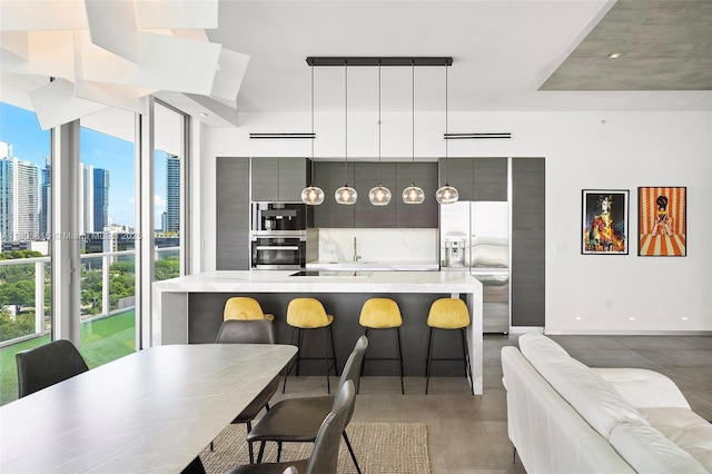 3470 E Coast Ave Unit H1201, Miami, FL 33137 - kitchen with stainless steel appliances, light countertops, a view of skyline, baseboards, and a spacious island