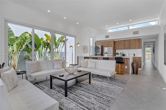 2345 SW 16th St, Miami, FL 33145 - living room with estacked washer and dryer, recessed lighting, concrete flooring, and a high ceiling