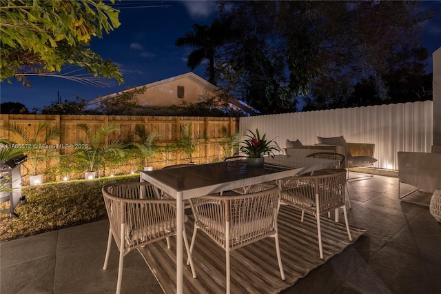 2345 SW 16th St, Miami, FL 33145 - patio at night with outdoor dining area and a fenced backyard
