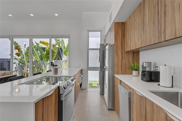 2345 SW 16th St, Miami, FL 33145 - kitchen with modern cabinets, appliances with stainless steel finishes, brown cabinetry, light tile patterned floors, and recessed lighting
