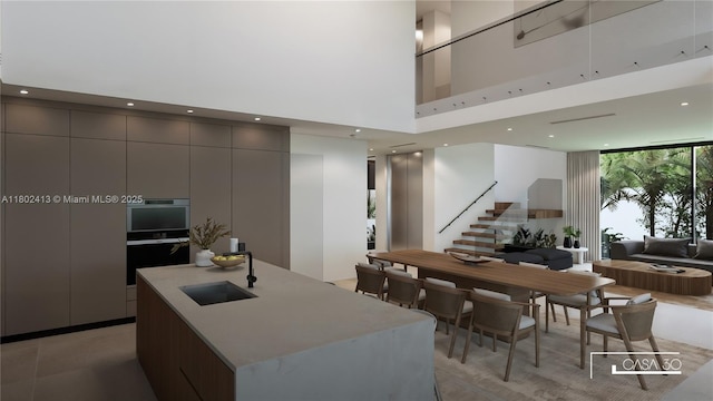 30 Samana Dr, Coconut Grove, FL 33133 - kitchen featuring modern cabinets, a sink, a towering ceiling, open floor plan, and a kitchen island with sink