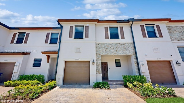 10004 SW 231st Ln, Miami, FL 33190 - view of property with an attached garage, stone siding, stucco siding, and driveway