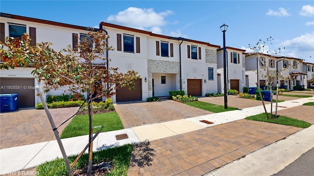 10004 SW 231st Ln, Miami, FL 33190 - view of property with decorative driveway, a residential view, stucco siding, and an attached garage