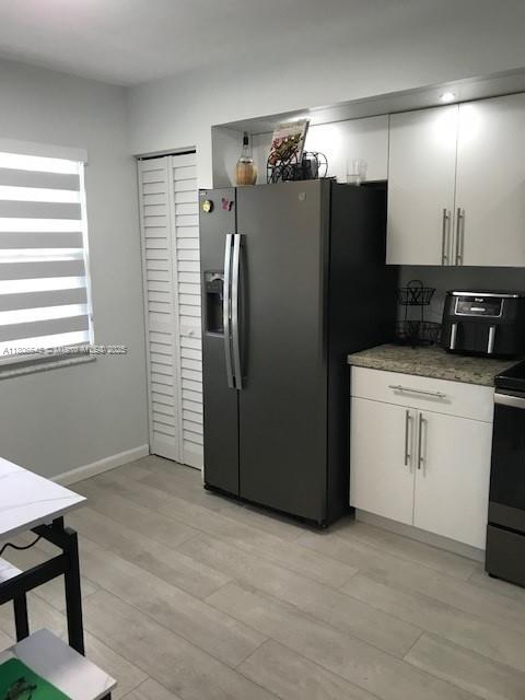 12500 SW 5th Ct Unit 210M, Pembroke Pines, FL 33027 - kitchen with fridge with ice dispenser, electric stove, white cabinets, and light wood-style flooring