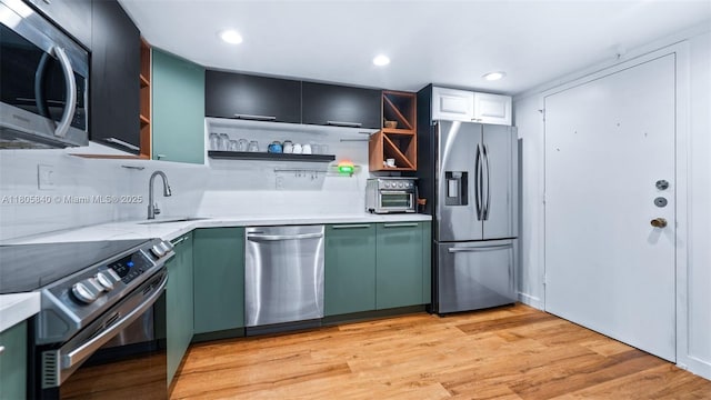 2750 NE 183rd St Unit 1610, Aventura, FL 33160 - kitchen featuring appliances with stainless steel finishes, open shelves, a sink, backsplash, and green cabinetry
