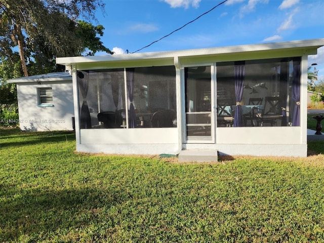 812 Lake Mcgregor Dr, Fort Myers, FL 33919 - back of property with a sunroom and a lawn