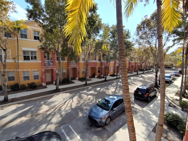 view of asphalt street with sidewalks and curbs