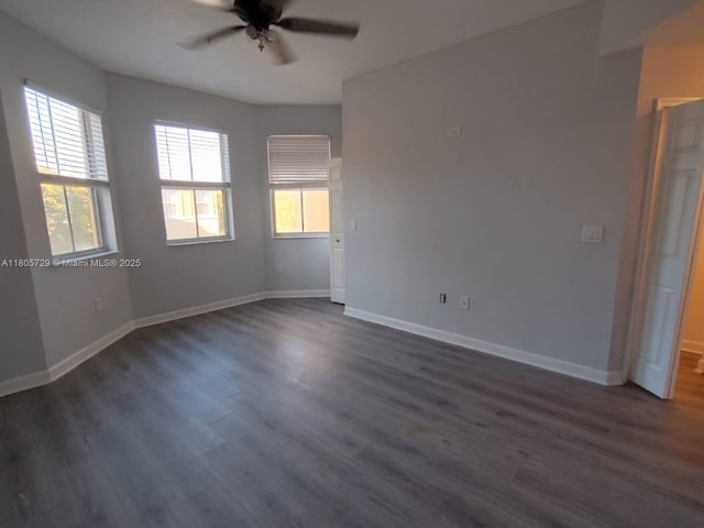 empty room featuring ceiling fan, dark wood-style floors, and baseboards