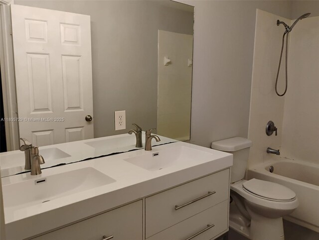 full bath with toilet, double vanity, and washtub / shower combination