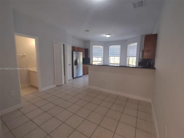 unfurnished room with light tile patterned floors and baseboards