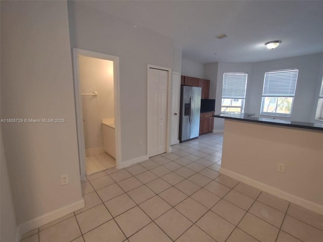 empty room featuring light tile patterned flooring and baseboards