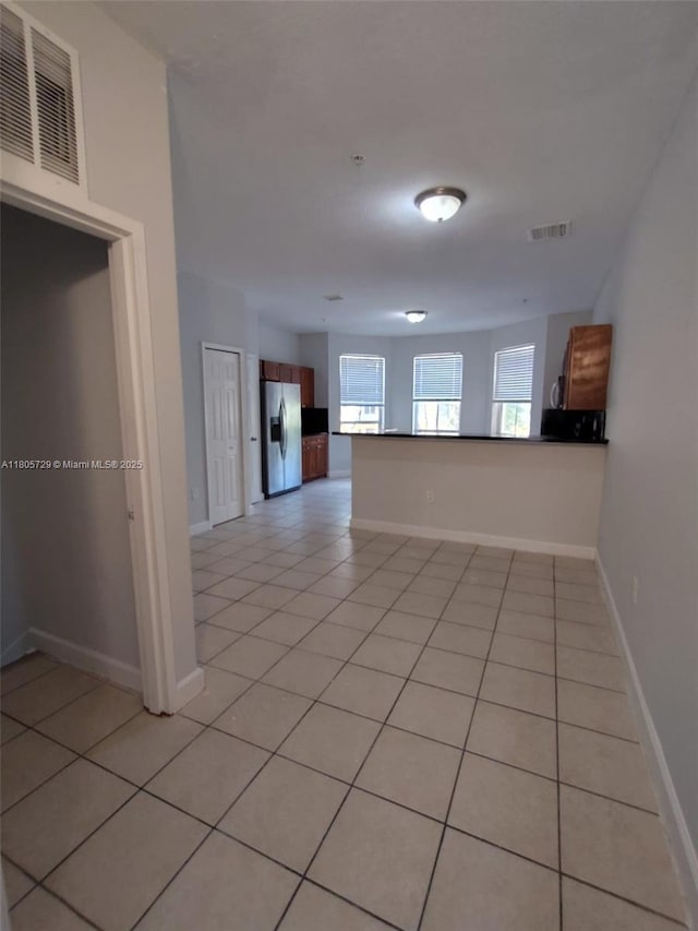 spare room with light tile patterned flooring and baseboards
