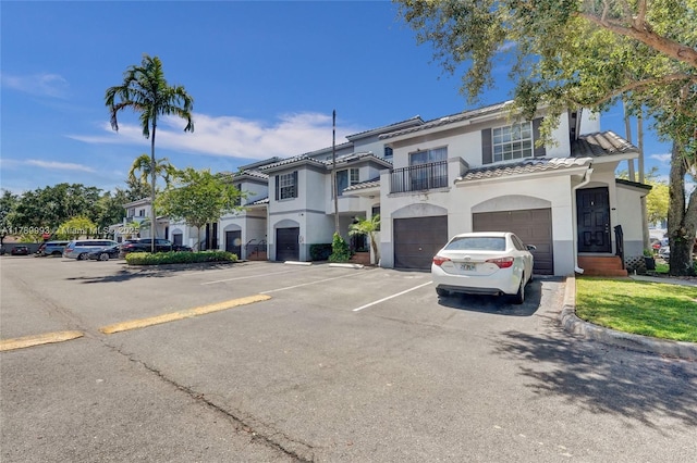 781 SW 148th Ave Unit 1514, Sunrise, FL 33325 - view of front of home featuring a balcony, stucco siding, a tile roof, uncovered parking, and an attached garage