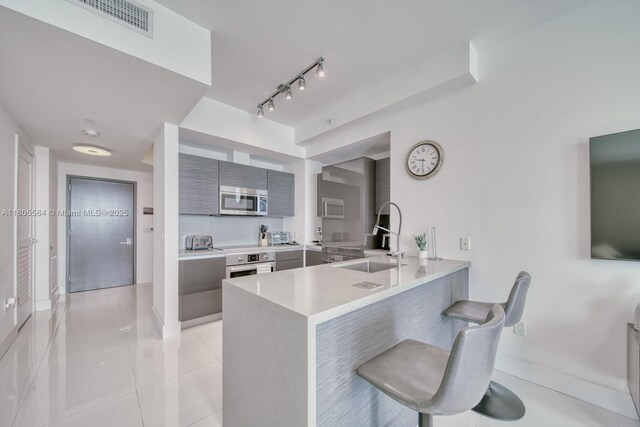 1080 Brickell Ave Unit 3802, Miami, FL 33131 - kitchen with appliances with stainless steel finishes, modern cabinets, a sink, light countertops, and a peninsula