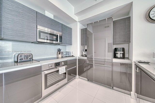 1080 Brickell Ave Unit 3802, Miami, FL 33131 - kitchen featuring stainless steel appliances, gray cabinets, light countertops, and modern cabinets