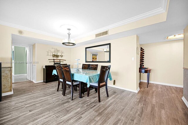 2655 Collins Ave Unit 1501, Miami Beach, FL 33140 - dining room with wood finished floors, crown molding, baseboards, a chandelier, and a tray ceiling