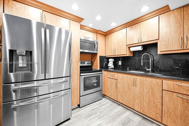 2655 Collins Ave Unit 1501, Miami Beach, FL 33140 - kitchen with stainless steel appliances, a sink, dark stone countertops, tasteful backsplash, and light wood-style flooring