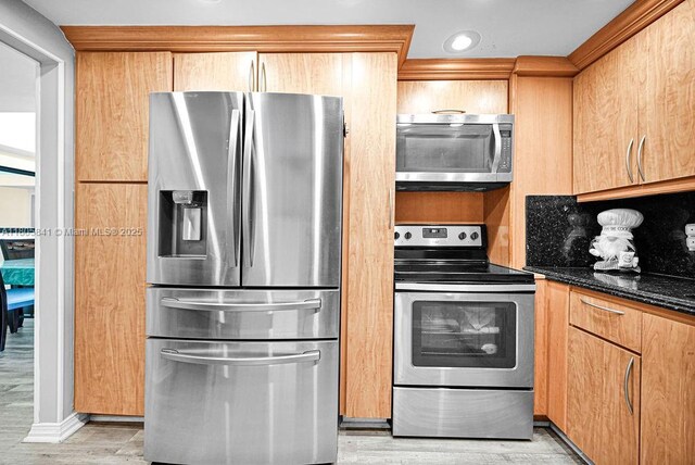 2655 Collins Ave Unit 1501, Miami Beach, FL 33140 - kitchen featuring stainless steel appliances, light wood-style flooring, and dark stone counters