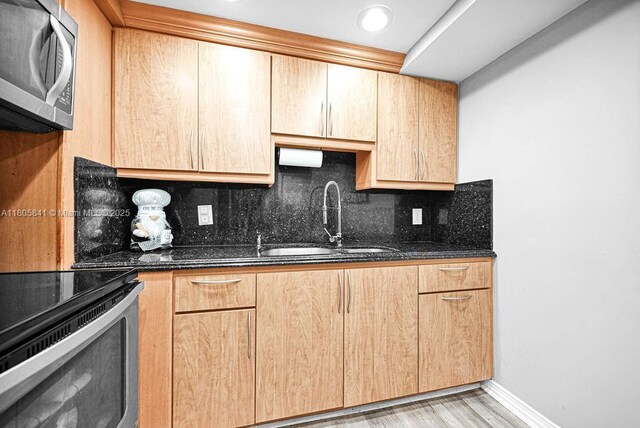 2655 Collins Ave Unit 1501, Miami Beach, FL 33140 - kitchen featuring stainless steel appliances, a sink, decorative backsplash, dark stone countertops, and light brown cabinets