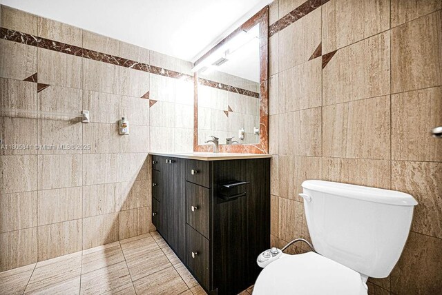 2655 Collins Ave Unit 1501, Miami Beach, FL 33140 - bathroom featuring tile walls, vanity, toilet, and tile patterned floors