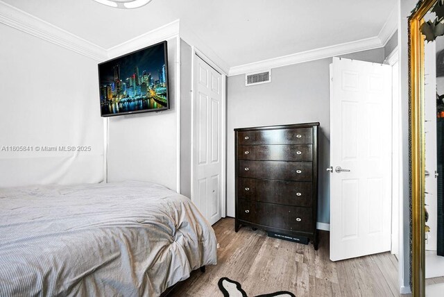 2655 Collins Ave Unit 1501, Miami Beach, FL 33140 - bedroom featuring crown molding, wood finished floors, and a closet