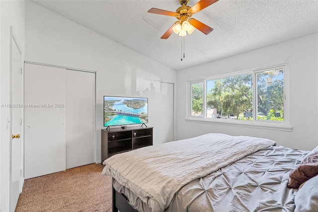 9808 NW 56th Pl, Coral Springs, FL 33076 - bedroom with two closets, light colored carpet, a textured ceiling, lofted ceiling, and ceiling fan