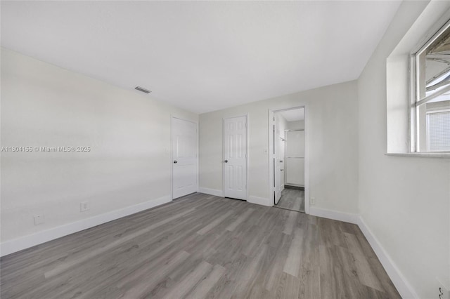 unfurnished bedroom featuring wood finished floors and baseboards
