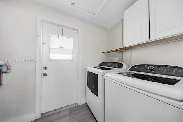 laundry room with cabinet space, washer and clothes dryer, light wood-style flooring, and baseboards